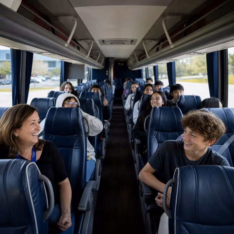 Group boarding a white charter bus for School Transportation transportation in Pittsburgh