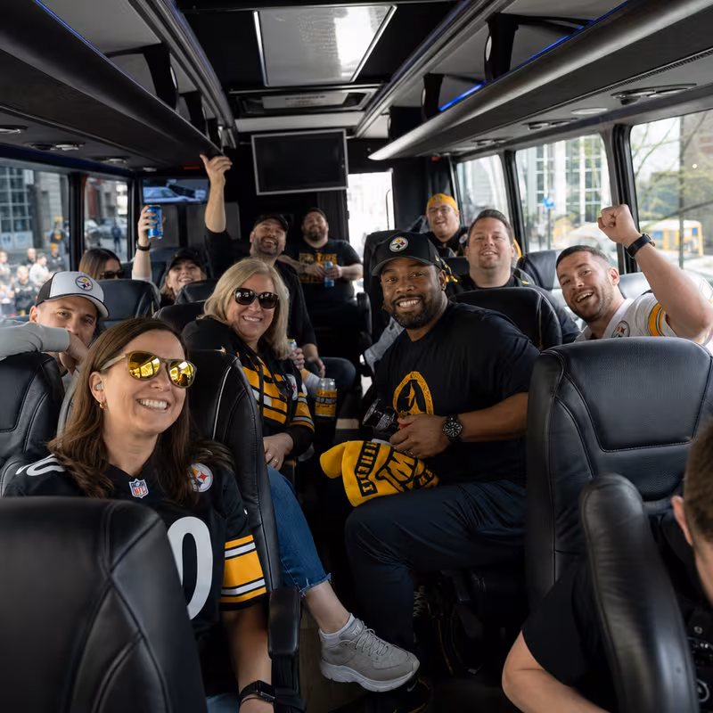 Group boarding a white charter bus for Sporting Event Transportation transportation in Pittsburgh